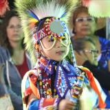 Ein kleines Kind trägt traditionellen Schmuck der First Nations