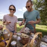 Eine Frau und ein Mann picknicken zusammen und sind dabei gut gelaunt.