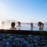 Ein Gruppe entspannt in einem Schwimmbecken.