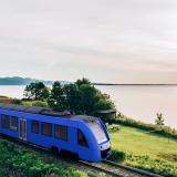 Erster Blauer Wasserstoffzug fährt vor einem See