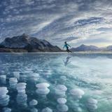 Schlittschuhläuferin auf dem Abraham Lake mit gefrorenen Eisblasen